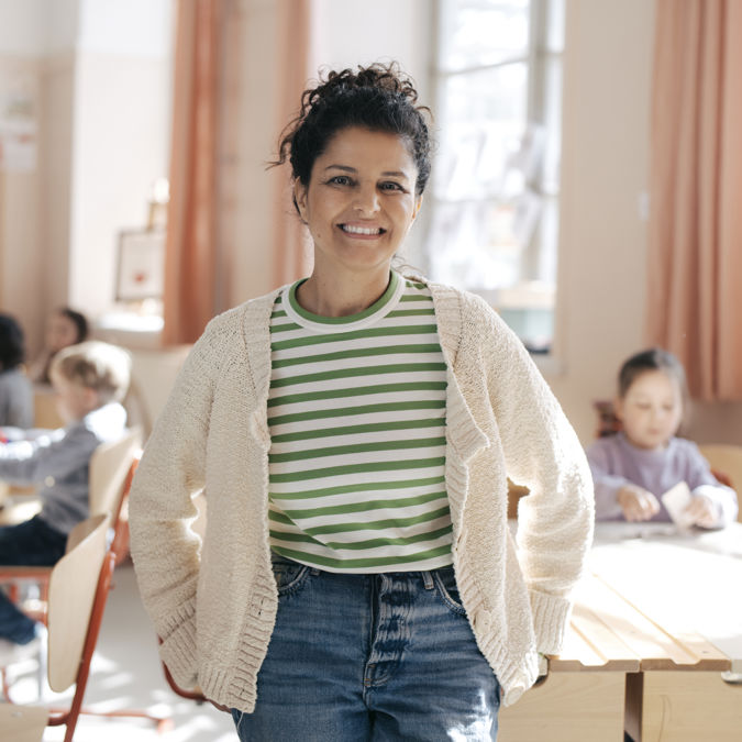 Leende kvinnlig förskollärare inomhus.